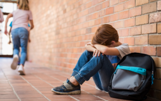 Sad child sitting on floor